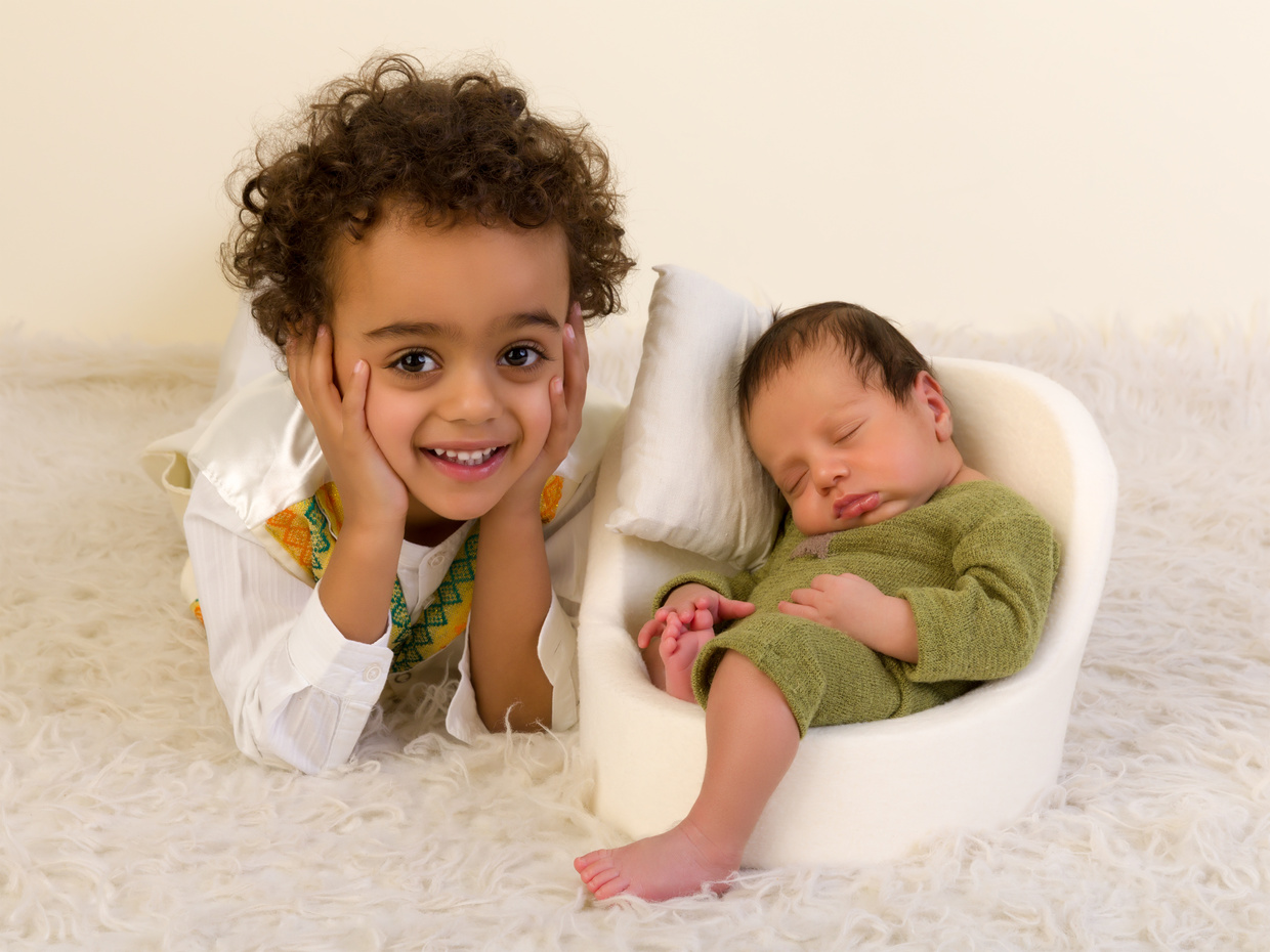 Happy Sibling with Newborn Baby
